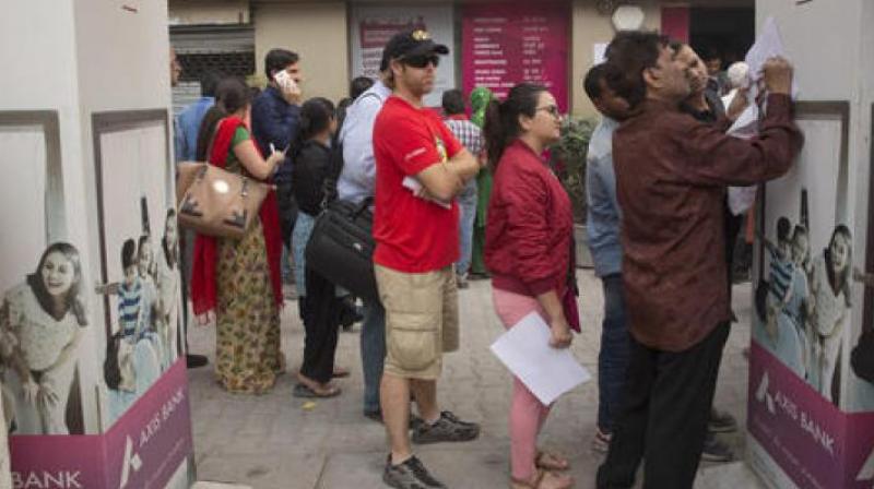 Foreign tourist stand in a queue to exchange discontinued currency notes outside a bank in New Delhi. (Photo: PTI)