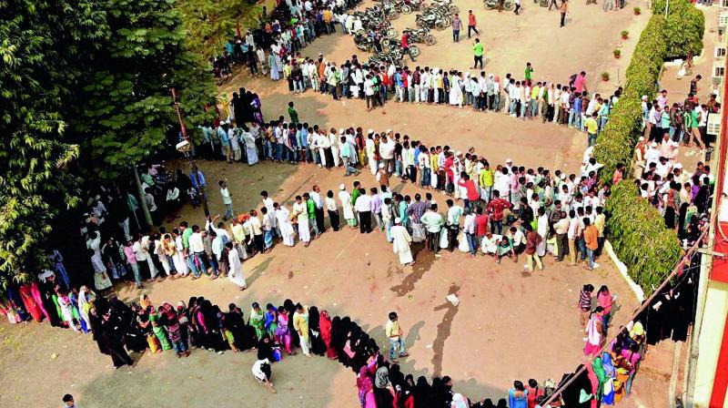 People stand in a massive queue outside a bank to exchange their old Rs 500 and Rs 1,000 notes in Varanasi on Sunday.  (Photo: PTI)