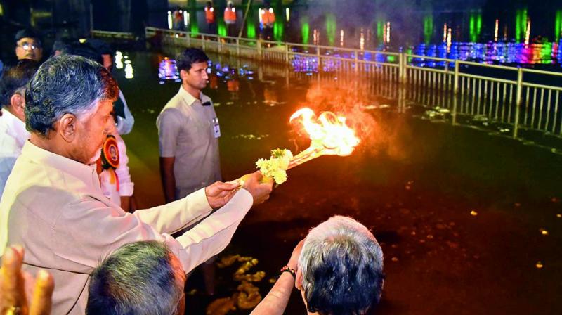 Chief Minister N. Chandrababu Naidu offers harathi to Prakasam barrage after completion of 60 years at Durgaghat in Vijayawada on Friday. (Photo: DC)