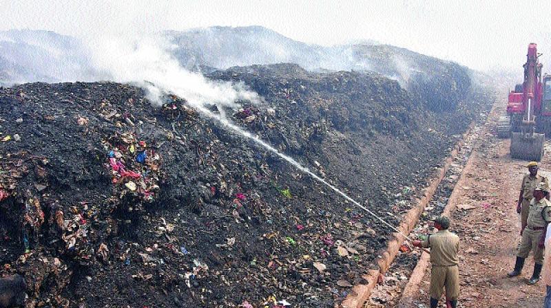 Fire personnel control the fire at the garbage dumping yard near Pipula Road Centre in Vijayawada on Wednesday.  	(Photo: DECCAN CHRONICLE)