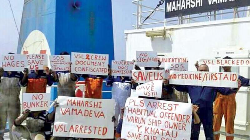 Crew members of the ship Maharshi Vamadeva stand on the vessels deck holding placards calling for help. (Photo by special arrangement )