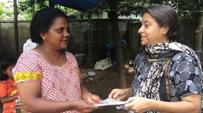 Weaver Philomena receives Rs 15,000 to repair her loom from an NGO.