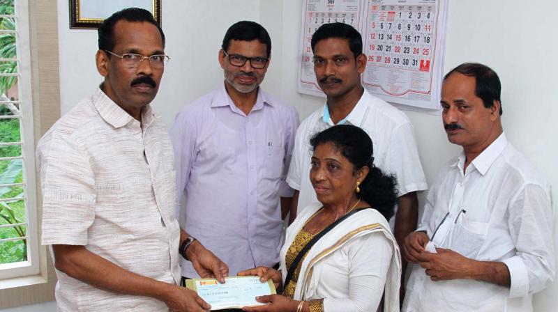 Diana Lisy hands over cheque to excise minister T.P Ramakrishnan at Perambra in Kozhikode.