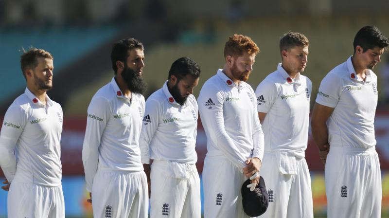 Alastair Cooks men wore the red flower symbol, which honours war dead, on the right collar of their shirts and held a minutes silence before play in the first Test against India in Rajkot. (Photo: AP)