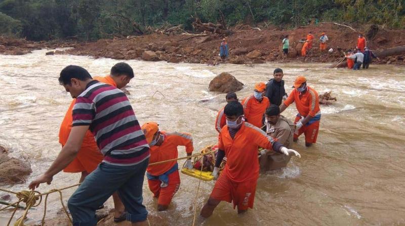 NDRF personnel shift a body found buried in the slush near Madikeri on Saturday	(Image: DC)