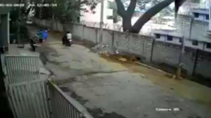 two bike borne men were seen assaulting a woman after a failed attempt of snatching her chain in front of her house in Bengalurus Rajarajeshwari Nagar. (Screengrab | ANI)