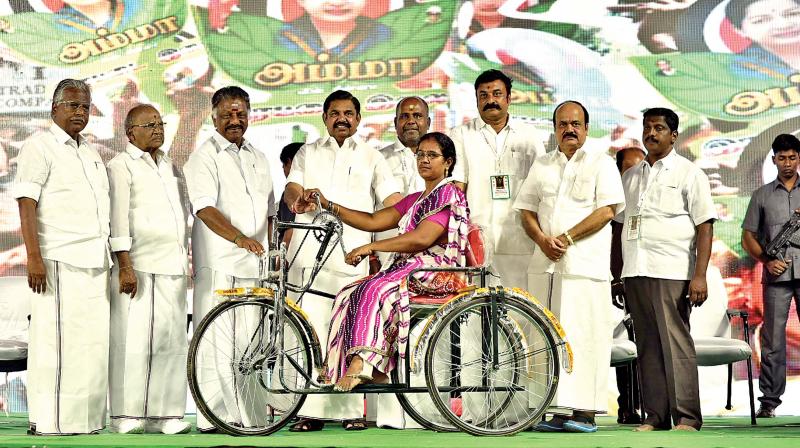 Chief Minister Edappadi K. Palaniswami and Deputy Chief Minister O. Panneerselvam present a tricycle to differently abled at RK Nagar on Tuesday, as part of former CM  J. Jayalalithaas 70th birth anniversary celebrations. (Photo: DC)