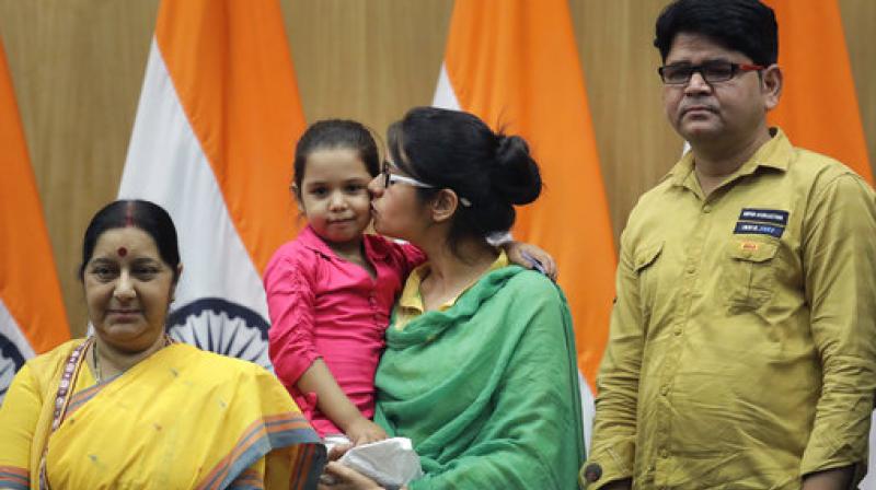 Uzma kisses her daughter Falak as she stands with Indian Foreign Minister Sushma Swaraj, left, and her brother during a press conference in New Delhi. (Photo: AP)