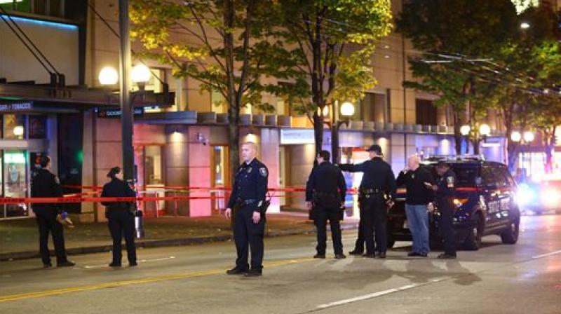 Law enforcement officers canvas the scene of a multiple victim shooting near Third Avenue and Pike Street in downtown Seattle. (Photo: AP)