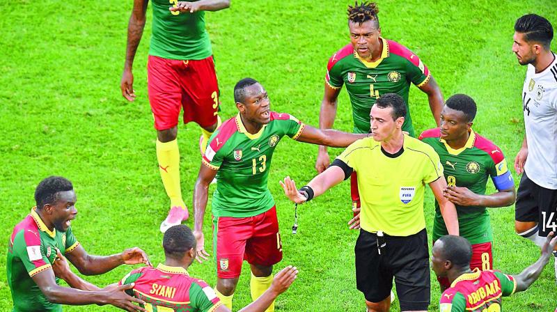 Cameroon players appeal to Colombian referee Wilmar Roldan in their match against Germany. (Photo: AFP)
