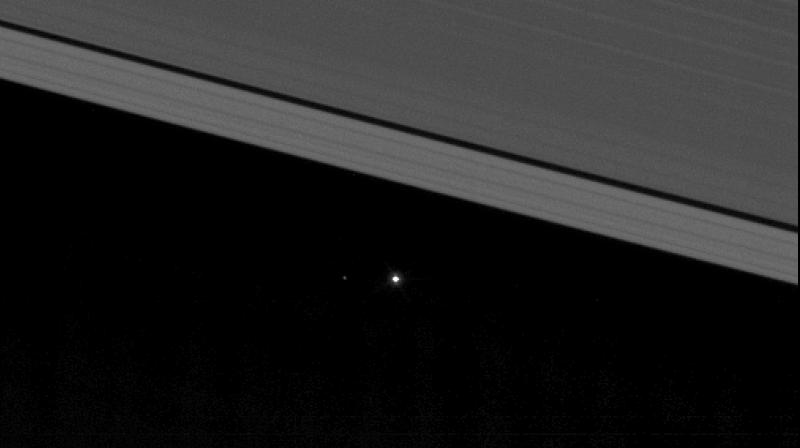 This view from NASAs Cassini spacecraft shows planet Earth as a point of light between the icy rings of Saturn. (Image: NASA)