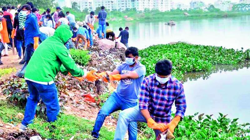 As part of the Swachh internship programme by the GHMC, students take part in Hussainsagar lake cleaning activity on Monday. Plastic waste stuck on the banks of lake which is causing foul smell has been cleaned by the interns. (Photo: DC)