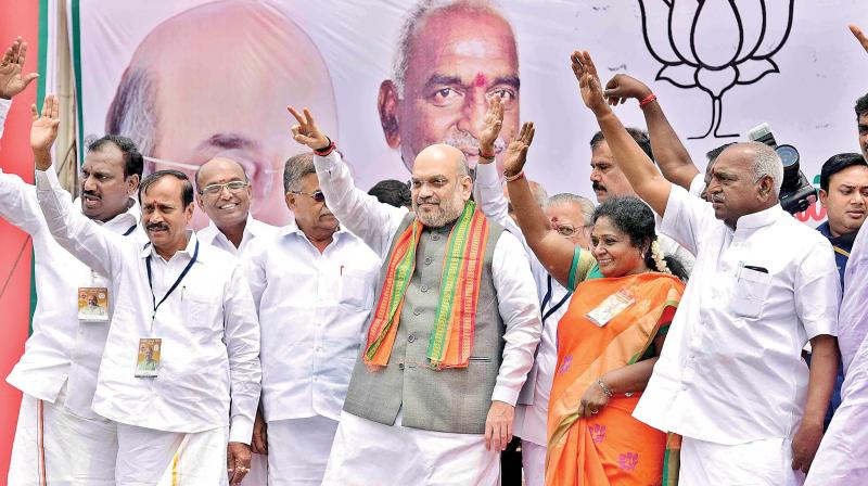 BJP national chief Amit Shah waves the victory symbol at party members when he was accorded a rousing reception at the Chennai airport on Monday (Photo: DC)