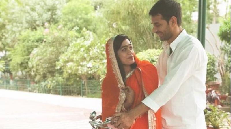 In the photo, Aishwarya is donning an orange and gold sari and she has covered her head like a bride, as she looks at Tej Pratap, who is clad in a white kurta-pyjama. (Photo: Instagram screengrab)