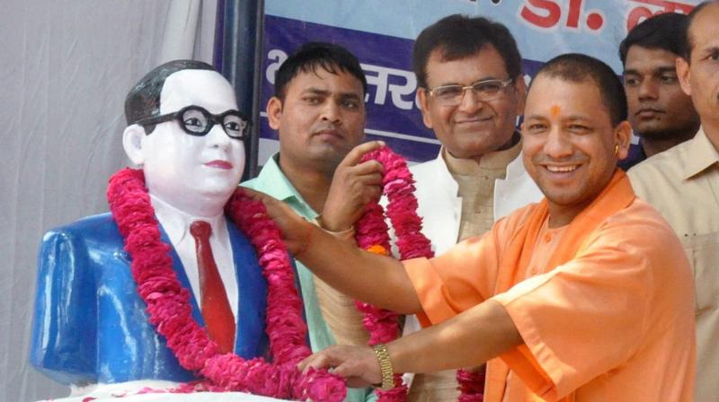 Uttar Pradesh Chief Minister Yogi Adityanath offering tributes to Dr B R Ambedkar on his 126th birth anniversary at Ambedkar memorial in Lucknow on Friday. (Photo: PTI)