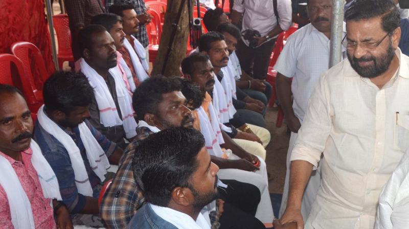 Minister Kadakampalli Surendran greets fishermen of Poovar and Vizhinjam who participated in the rescue operations in flooded Alappuzha during a honoring programme in Thiruvananthapuram on Monday.(Photo: DC)