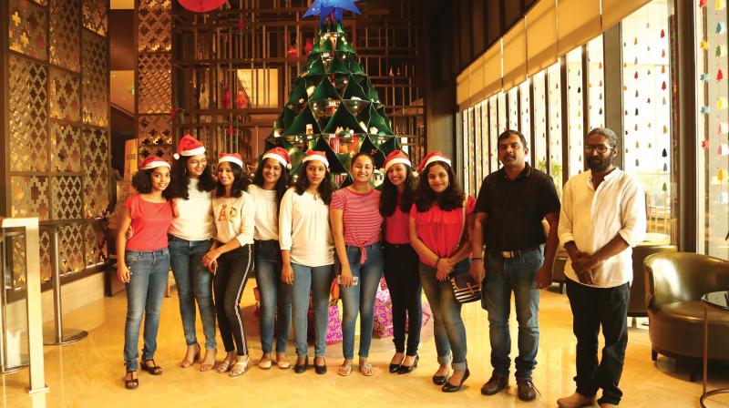 People pose with a 12-foot no-plastic Christmas tree installed at a hotel in Kochi