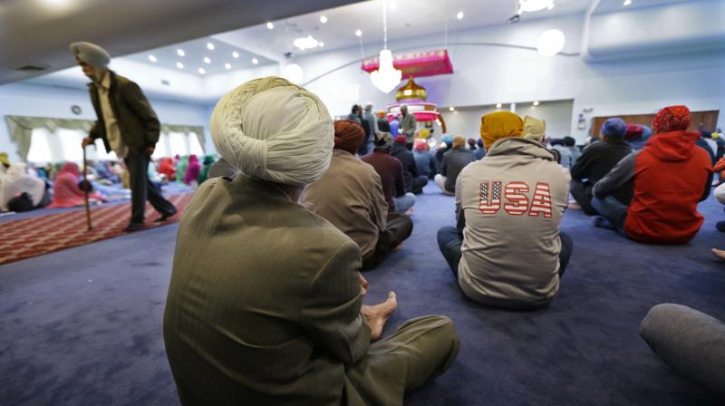 Men and women, including a man wearing a \USA\ sweatshirt, attend Sunday services at the Gurudwara Singh Sabha of Washington. (Photo: AP)