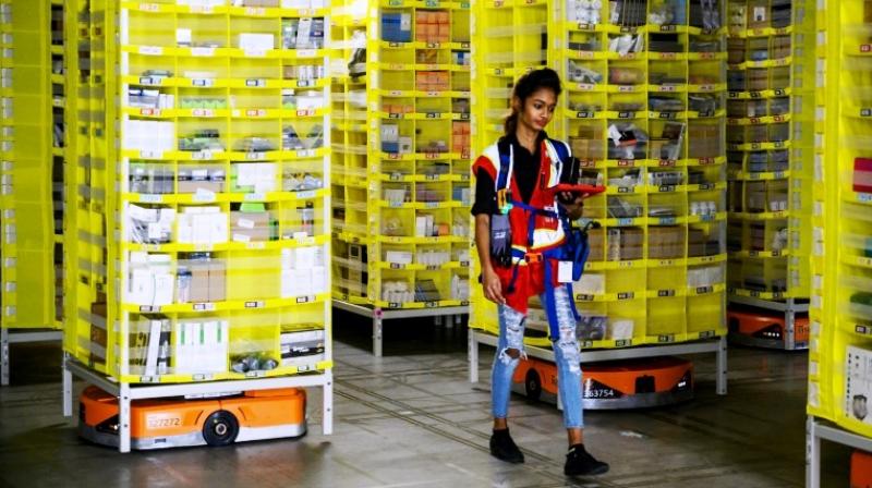 Amazon employee Deasahni Bernard moves among robots at the 855,000-square-foot Amazon fulfilment centre in Staten Island. (Photo: AFP)