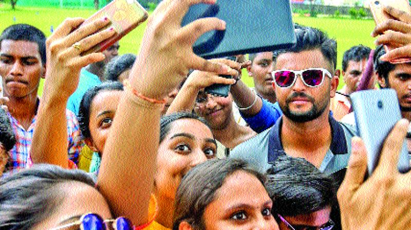 Suresh Raina poses for a selfie with fans.