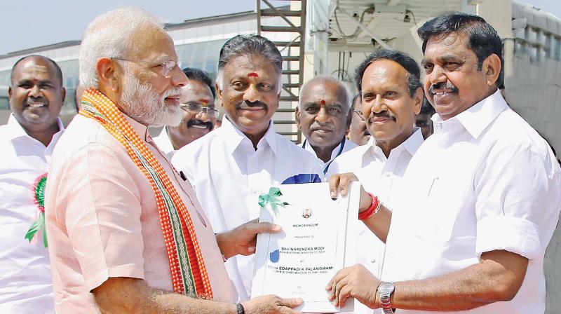 Chief Minister Edappadi K. Palaniswami presenting a memorandum to Prime Minister Narendra Modi at the Madurai airport on Monday. Deputy Chief Minister  O. Panneerselvam is also seen. (DC)