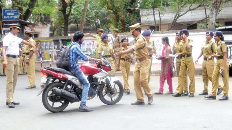 A policeman stopping a helmetless rider as a part of an awareness campaign. (File pic)