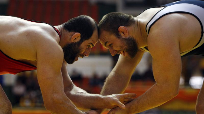 Irans Fardin Masoumi (L) and his American opponent Tervel Dlagnev during the Takhti Wrestling Cup. (Photo: AP)