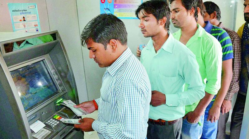 File picture of people using an ATM machine in Hyderabad.