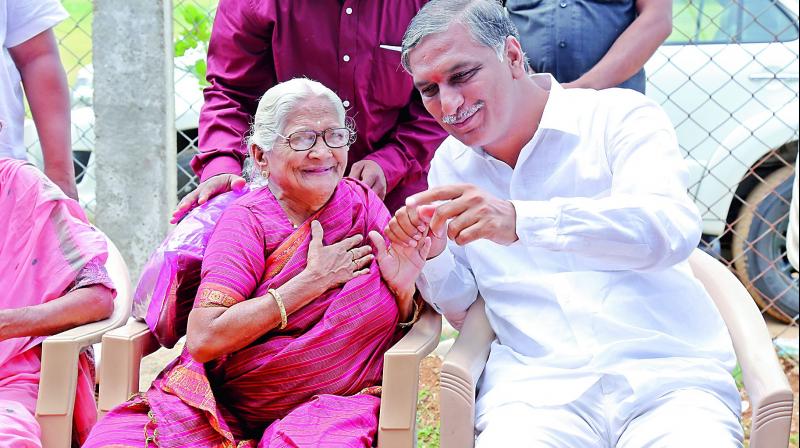 Irrigation minister T. Harish Rao shares a lighter moment with an elderly woman. (Photo: DC)