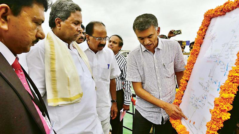 Agriculture Minister Krishna Byregowda briefs CM Siddaramaiah and MP Veerappa Moily about a development project in Devanahalli on Friday. (Photo: DC)