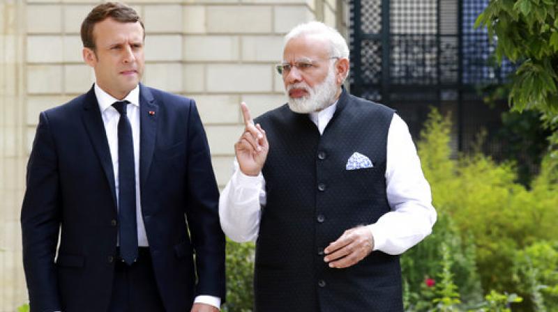 French President Emmanuel Macron, left, speaks with Prime Minister Narendra Modi, in the gardens of the Elysee Palace in Paris, France. (Photo: AP)