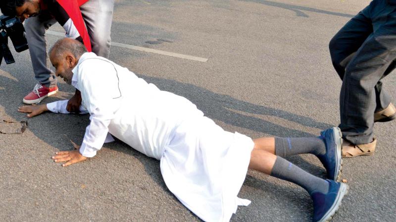 District in-charge minister G.T. Devegowda trips and falls in Mysuru on Sunday. (Photo:KPN)