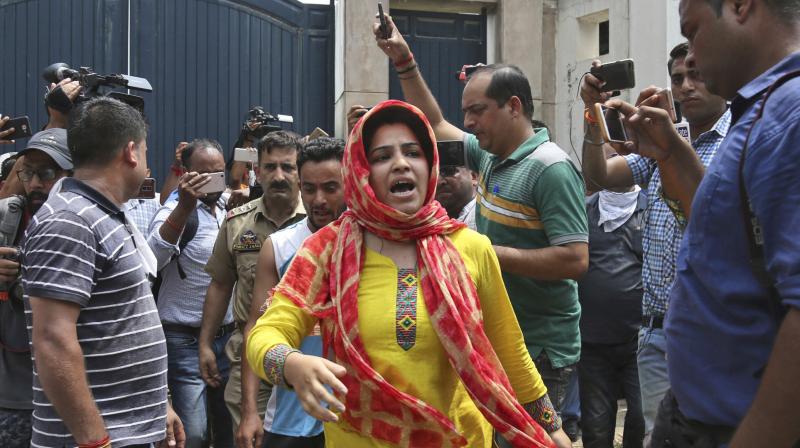 A woman whose brother was killed inside the residence of Farooq Abdullah protests outside the residence. (Photo: AP)