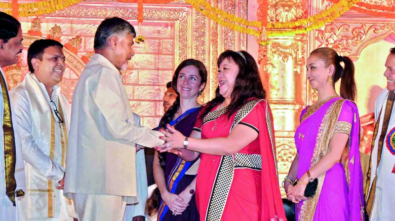 Chief Minister N. Chandrababu Naidu interacts with foreigners at the Fifth International Kuchipudi convention  in Vijayawada on Friday. (Photo: DC)