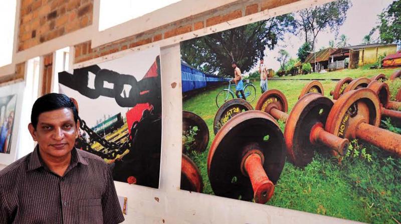 Photojournalist Sivaji Kumar with his pictures put on exhibition. (Photo: DC)