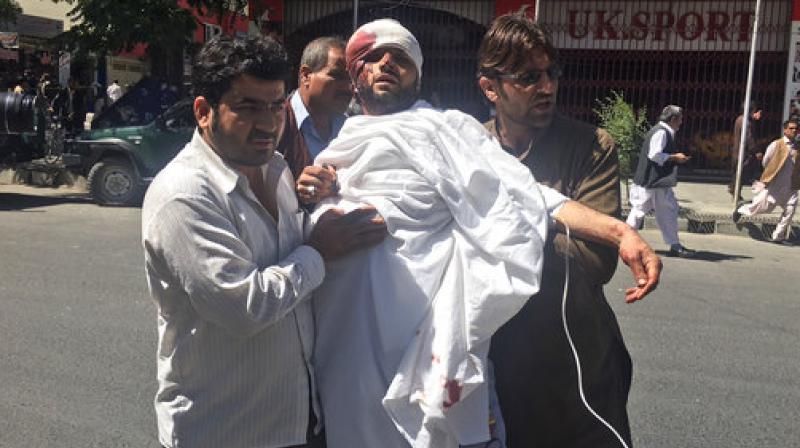 People carry an injured man after a suicide attack in Kabul, Afghanistan, Wednesday. (Photo: AP)