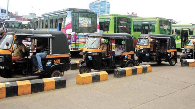 Auto rickshaw drivers wait for their turn in an auto stand in Kozhikode