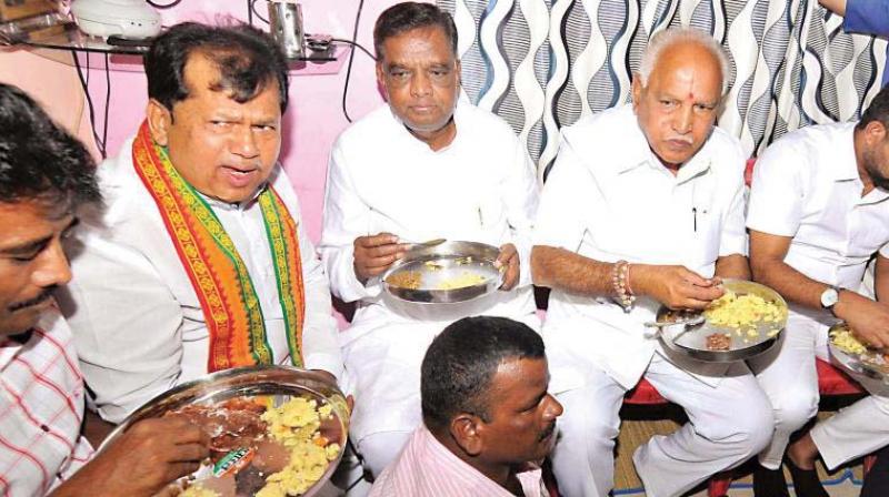A file photo of state BJP leaders B.S. Yeddyurappa, and Srinivasprasad having breakfast at a dalits house in north Karnataka