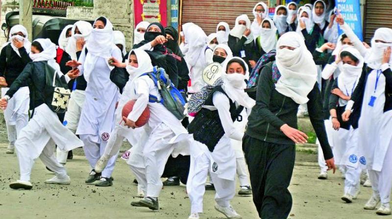 Girl students pelt stones at security personnel during clashes in the vicinity of Lal Chowk in Srinagar on Monday. (Photo: PTI)