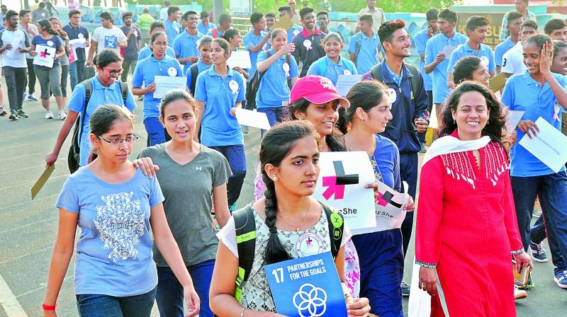 Youngsters participate in a walkathon on the eve of International Womens Day, on the Beach Road in Visakhapatnam on Wednesday. (Photo: DC)