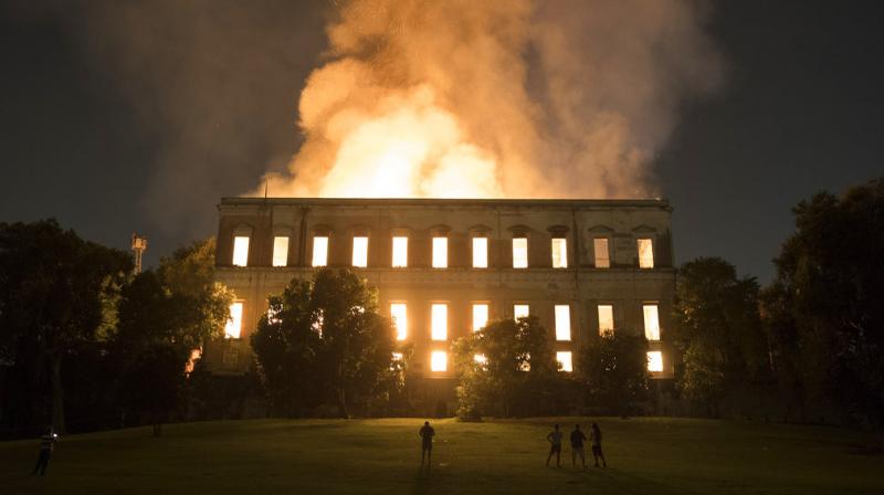 People watch as flames engulf the 200-year-old National Museum of Brazil, in Rio de Janeiro, Sunday, Sept. 2, 2018. According to its website, the museum has thousands of items related to the history of Brazil and other countries. The museum is part of the Federal University of Rio de Janeiro. (Photo: AP)