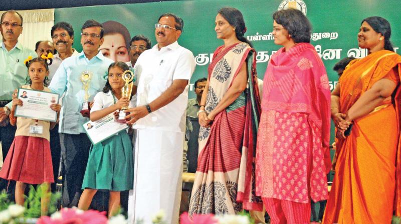 School education minister Ma Foi Pandiarajan gives awards for meritorious  students during Childrens Day celebrations on Monday. School education  secretary Sabitha also seen (Photo: DC)