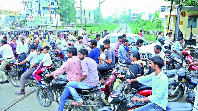 Motorists are frequently stranded in traffic snarls at the level crossing in Nehru Nagar, near Manipuram flyover, in Guntur. 	(Photo: DC)