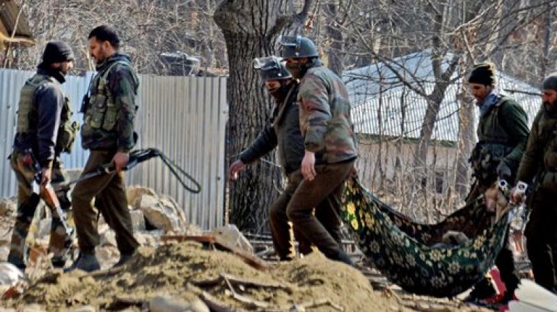 Special Operation Group (SOG) of Jammu and Kashmir police carrying the body of a militant which was recovered from the rubbles of destroyed house where militants were hiding during an encounter at Frisal area of Kulgam district of South Kashmir on Sunday. (Photo: PTI)