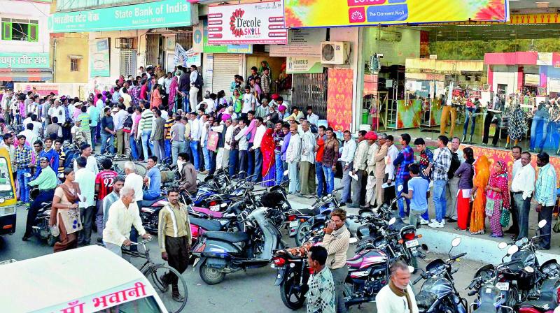 People queue up outside a State Bank of India branch to exchange their old Rs 500 and 1,000 notes in Beawar on Friday. (Photo: PTI)