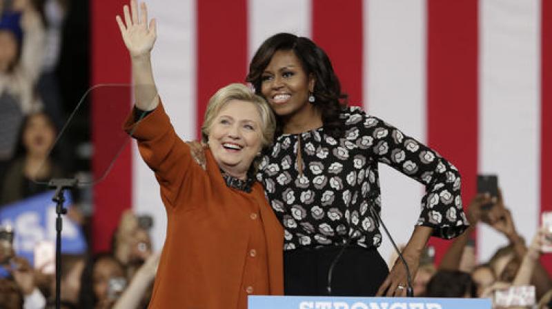 Democratic presidential candidate Hillary Clinton, accompanied by first lady Michelle Obama, greet supporters during a campaign rally in Winston-Salem, N.C. (Photo: AP)