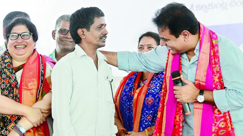 Minister K.T. Rama Rao interacts with weavers at the launch of an exhibition on the occasion of National Handloom Day at Peoples Plaza on Necklace road in Hyderabad on Tuesday. 	 DC