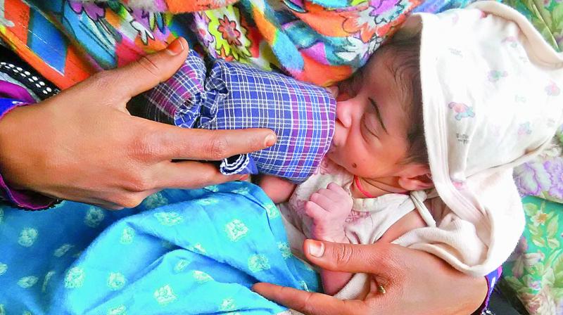 20-year-old Nusrat Begums baby being bottle fed by her sister Farzana Begum. (Photo: DC)