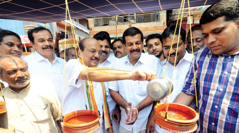 UDF candidate P.K.	 Kunhalikutty fills up water pots set up by Muslim League  workers for the birds to beat the scorching heat during his campaign in Kottakunnu in Malappuram on Monday. (Photo: DC)