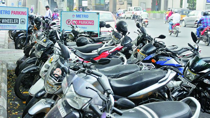 A line of two-wheelers parked outside the Tarnaka metro station beside a Parking and a No Parking board. (Photo: DC)